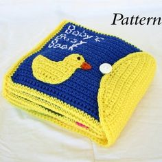 a crocheted book with a rubber ducky on it and the cover is blue and yellow