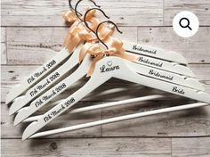 wedding hangers with personalized names on them and bows tied to the top one