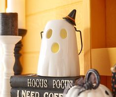 a stack of books sitting on top of a table next to a white ghost statue