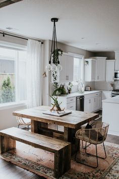 a kitchen with a table, chairs and a bench next to a window in it