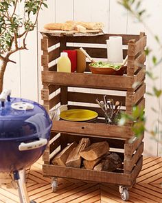 an outdoor bbq with food on it and a potted tree in the background