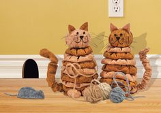 two cats made out of cookies sitting on top of a wooden floor next to a mouse