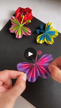 someone is making origami flowers out of paper