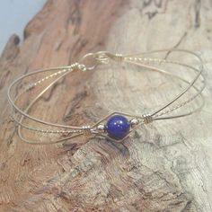 A sweet design of three strands of 14kt gold filled wire featuring a single 6mm genuine lapis bead flanked by two small 14kt gold filled beads. So delicate and feminine! It's likely that you have several blue outfits in your closet. Blue is the most cited favorite color of all! This stylish, well-fitting bangle will go with them all, and is sure to get noticed every time you wear it! The sturdy built-in hook and eye clasp is easy to get on and off by yourself. Choose your perfect size from the v Minimalist Hand Wrapped Adjustable Jewelry, Hand-strung Friendship Bracelet Jewelry, Hand-strung Friendship Bracelet, Delicate Jewelry With Round Beads For Friendship, Hand Wrapped Adjustable Jewelry For Gifts, Adjustable Delicate Bracelet Jewelry, Adjustable Wire Wrapped Jewelry, Delicate Adjustable Bracelet Jewelry, Adjustable Hand Wrapped Bracelet