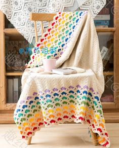 a crocheted table cloth on top of a wooden chair with a cup and saucer