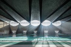 an empty swimming pool with sunbeams shining through the windows and reflecting light on the floor