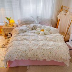 a bed with pillows and stuffed animals on it in a room next to a window