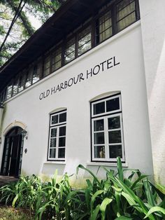 the old harbour hotel is white with black lettering on it's front and side windows