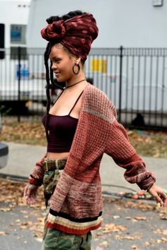 a woman walking down the street with her hair in a bun and wearing cargo pants