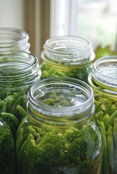 several jars filled with green beans and broccoli