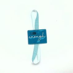 a blue and white lanyard with the words i am enough on it's side