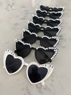 several pairs of black and white sunglasses sitting on top of a marble counter with the words bride to be written on them