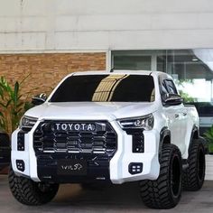 a white toyota truck parked in front of a building