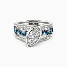 a white gold ring with blue and white diamonds on the sides, set in 18k white gold