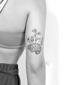 a black and white photo of a woman's arm with flowers on it