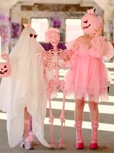 two girls dressed up in halloween costumes and one is wearing a ghost costume while the other girl wears a pink dress