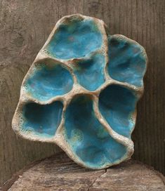 a piece of pottery sitting on top of a wooden table next to a tree stump