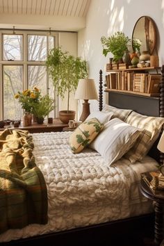 a bed with pillows and blankets on it in front of a window filled with potted plants