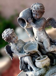 a statue of an angel drinking water from a fountain