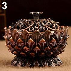 an ornate metal bowl sitting on top of a table