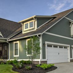 a large house with green siding and white trim