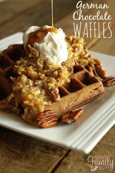 german chocolate waffles on a white plate topped with whipped cream and pecans