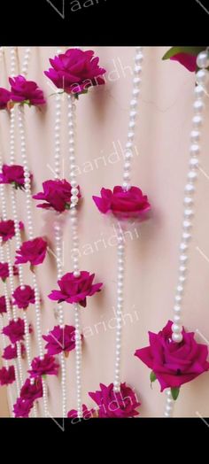 purple flowers and pearls are hanging on the wall