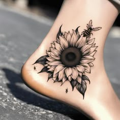 a sunflower and bee tattoo on the side of a woman's foot,