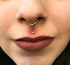 a close up of a woman with a nose ring and nose piercings on her nose