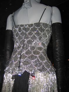 a mannequin dressed in silver sequins and black leather gloves