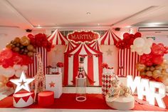 a circus themed birthday party with red and white balloons, gold stars, and giant letters