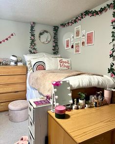 a bedroom decorated in pink and white with flowers on the wall