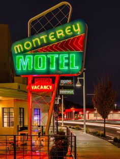 a neon sign for a motel lit up at night