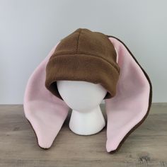 a white mannequin head with a brown and pink hat on top of it