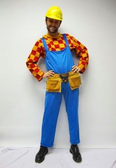 a man dressed up as a clown standing in front of a white wall with his hands on his hips