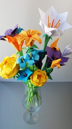 a vase filled with colorful origami flowers on top of a table