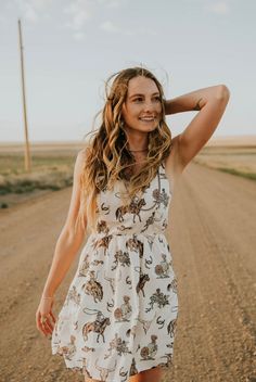 A Cactus Cowgirl Exclusive! The Darlin' Dress is the cutest short summer dress for rodeos, concerts, BBQ's and summer activities! Cream-colored with a cute western pattern. This dress is running true to size. Models are wearing the small and are both 5'4. See size chart below for dress length. Square neckline Fixed straps Zipper closure in the back Elastic waist Very lightweight Lined Size Dress Length (shoulder to bottom of dress) Small 32.5 inches Medium 33.5 inches Large 34.5 inches XLarge 35 Western Summer Dresses, Western Summer Outfits, Western Photo Shoots, Short Summer Dress, Western Summer, Dresses With Cowboy Boots, Western Pattern, Brown Cowboy Boots, Cute Country Outfits