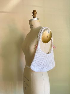 a mannequin wearing a white crochet purse