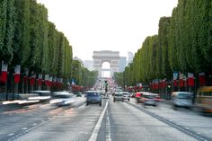 cars are driving down the street in front of an arc de trioe triumph gate