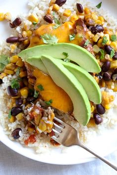 a white plate topped with rice, beans and avocado