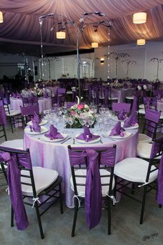 the tables are set with purple and white linens