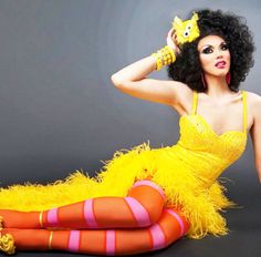 a woman in a yellow dress is sitting on the floor with her legs spread out