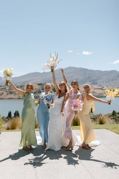 the bridesmaids are holding their bouquets high in the air while posing for a photo