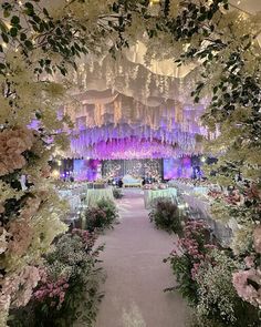 an elaborately decorated wedding venue with flowers and chandeliers hanging from the ceiling