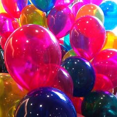 a bunch of balloons that are in the shape of heart - shaped shapes and colors