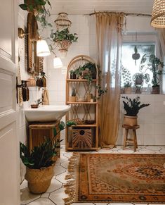 a bathroom with plants and rugs on the floor