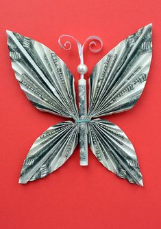 a butterfly made out of money on a red background