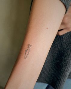 a woman's arm with a small tattoo on the left side of her arm