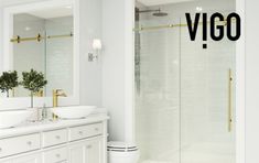 a white bathroom with two sinks and a walk in shower next to a large mirror