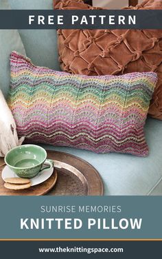 a knitted pillow sitting on top of a chair next to a cup and saucer